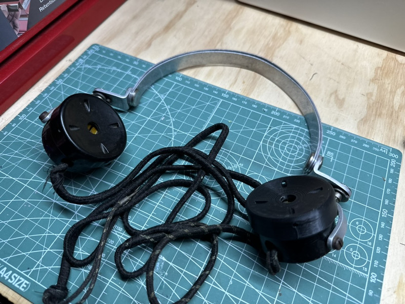 Pair of replacement black ear cups beside a vintage RAAF pilot headset